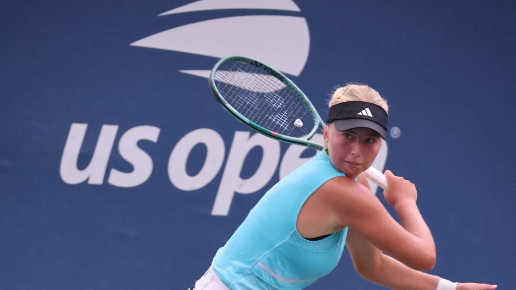 Clara Tauson følger igennem på et slag foran US Open-banderollen