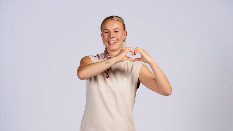 Mia Blichfeldt smiler og former et hjerte med hænderne i den danske OL-dragt