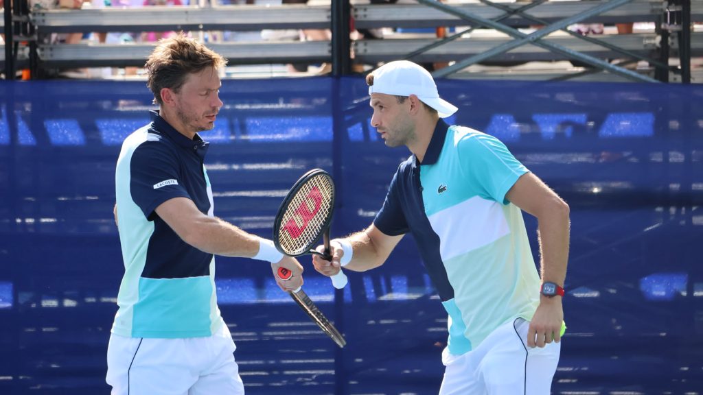Grigor Dimitrov og Nicolas Mahut giver hinanden en knytnæve mellem to bolde i en doublekamp ved DC Open i Washington 2023