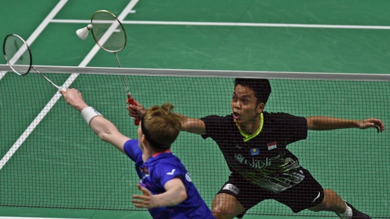 Anders Antonsen i blå trøje strækker sig mod nettet, mens Anthony Ginting returnerer fjerbolden i finalen ved Indonesia Masters 2020 i Jakarta